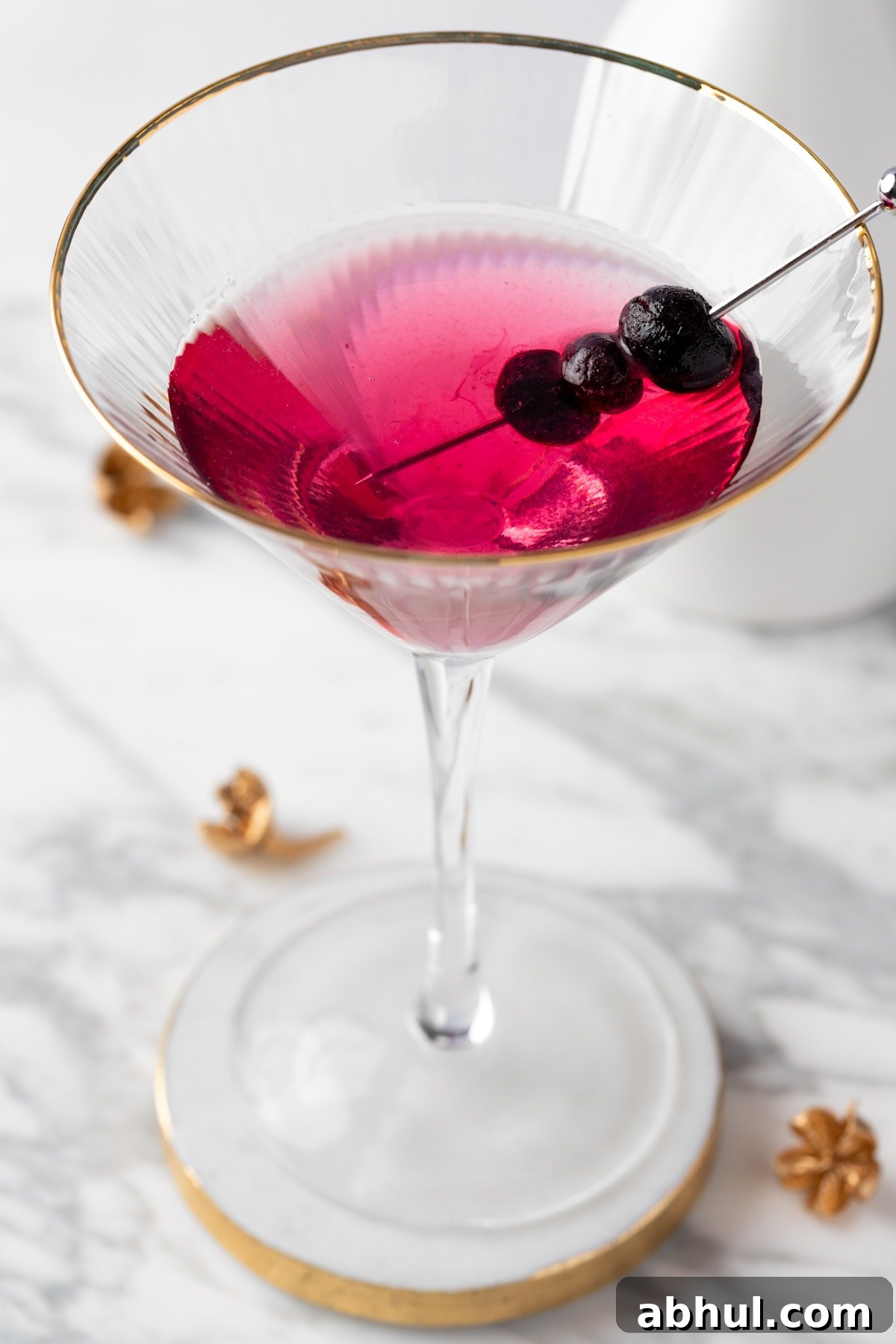 Blueberry Lemon Drop Martini Recipe & Cocktail Guide 2 A blueberry lemon drop martini on a white marble table.