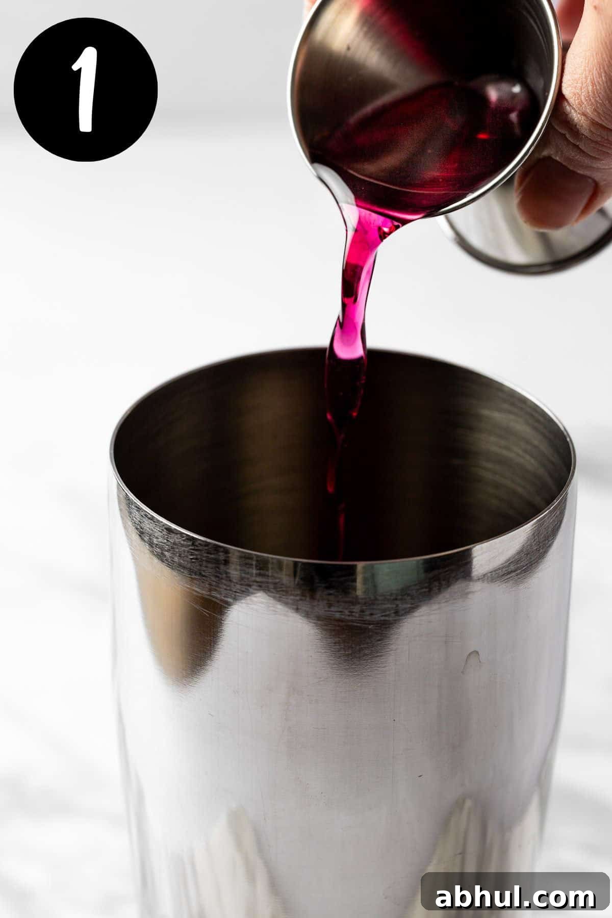Blueberry Lemon Drop Martini Recipe & Cocktail Guide 4 Pouring the blueberry syrup into a cocktail shaker.