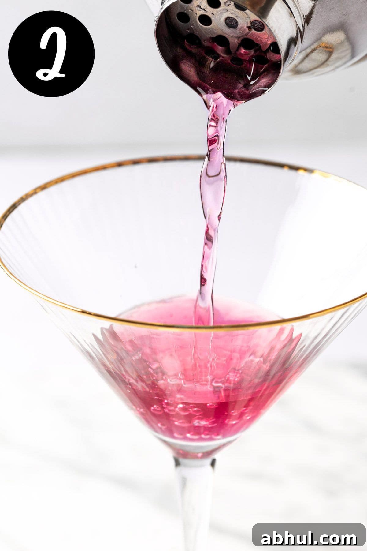 Blueberry Lemon Drop Martini Recipe & Cocktail Guide 5 Pouring the lemon drop martini from the cocktail shaker into a martini glass.