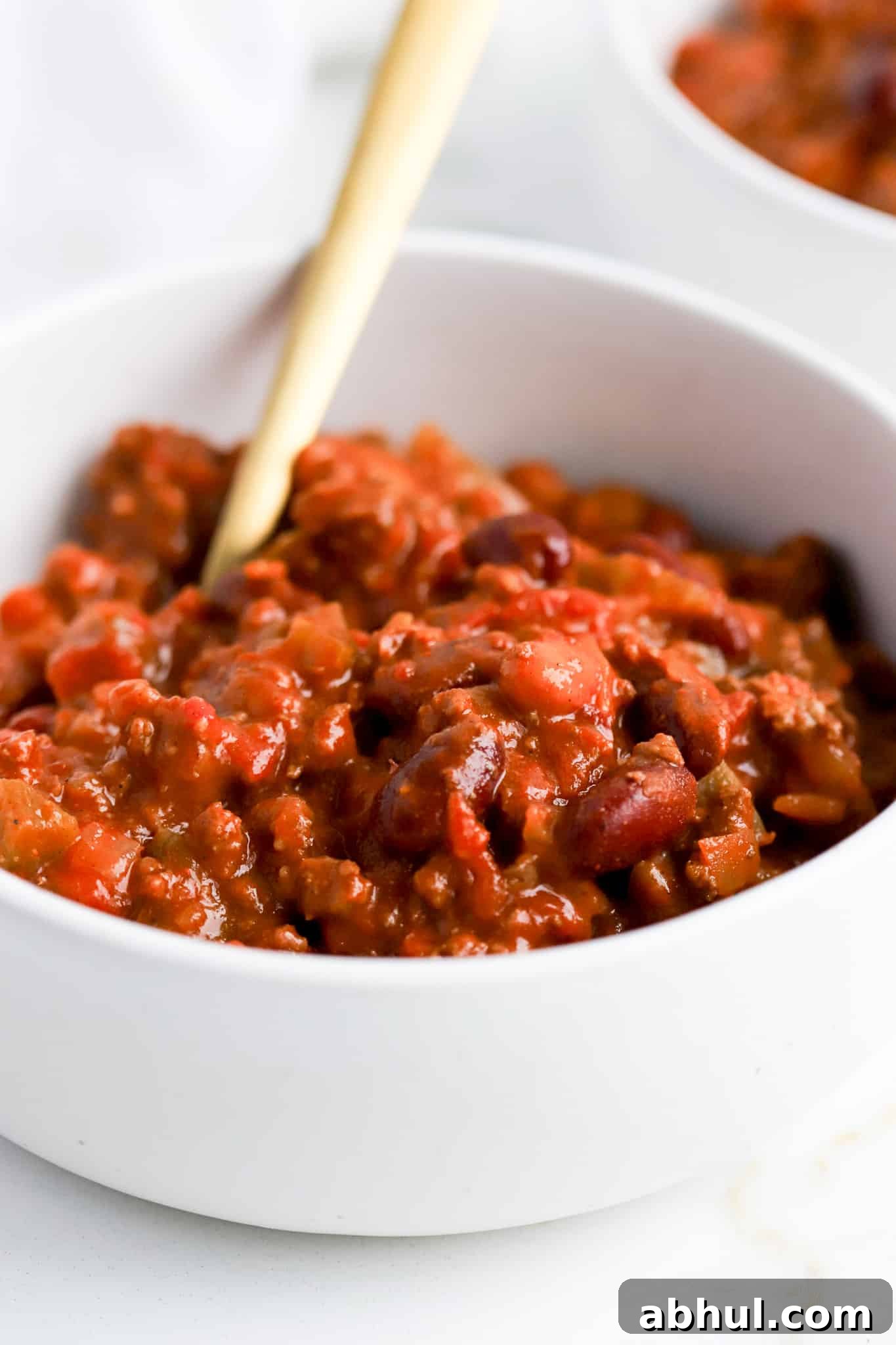 Wendy’s Copycat Chili Recipe: Make the Famous Secret Chili at Home 5 Wendys chili recipe with red kidney beans in white bowl and golf spoon