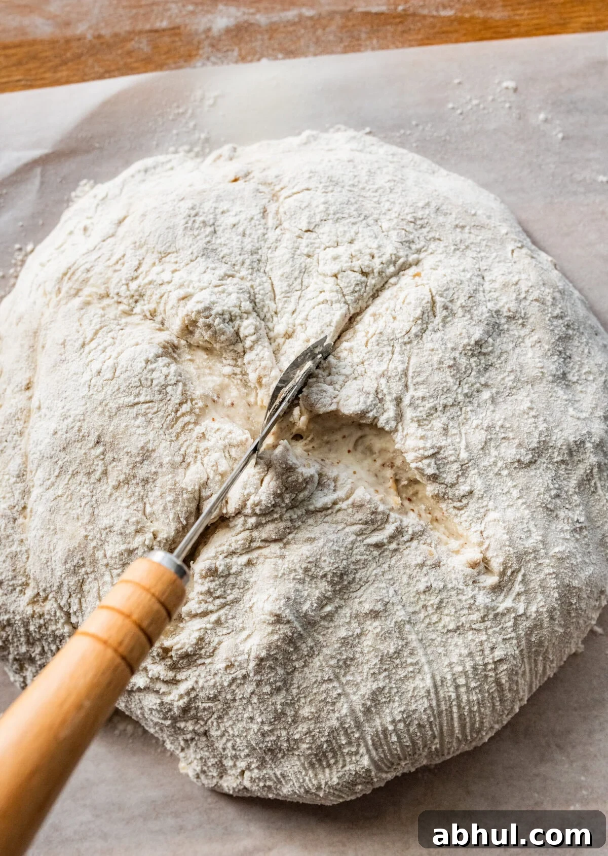 Using a knife to score the top of the bread boule. 