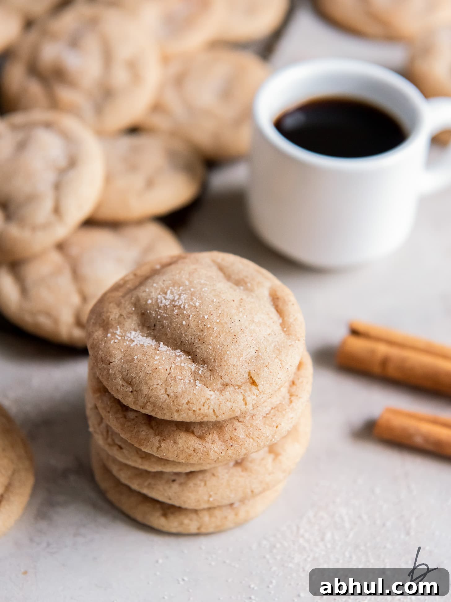 stack of chewy snickerdoodle cookies with cracked tops and cinnamon sugar.