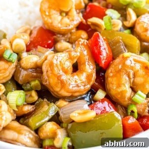 Kung Pao shrimp, shown with rice, garnished with green onions.