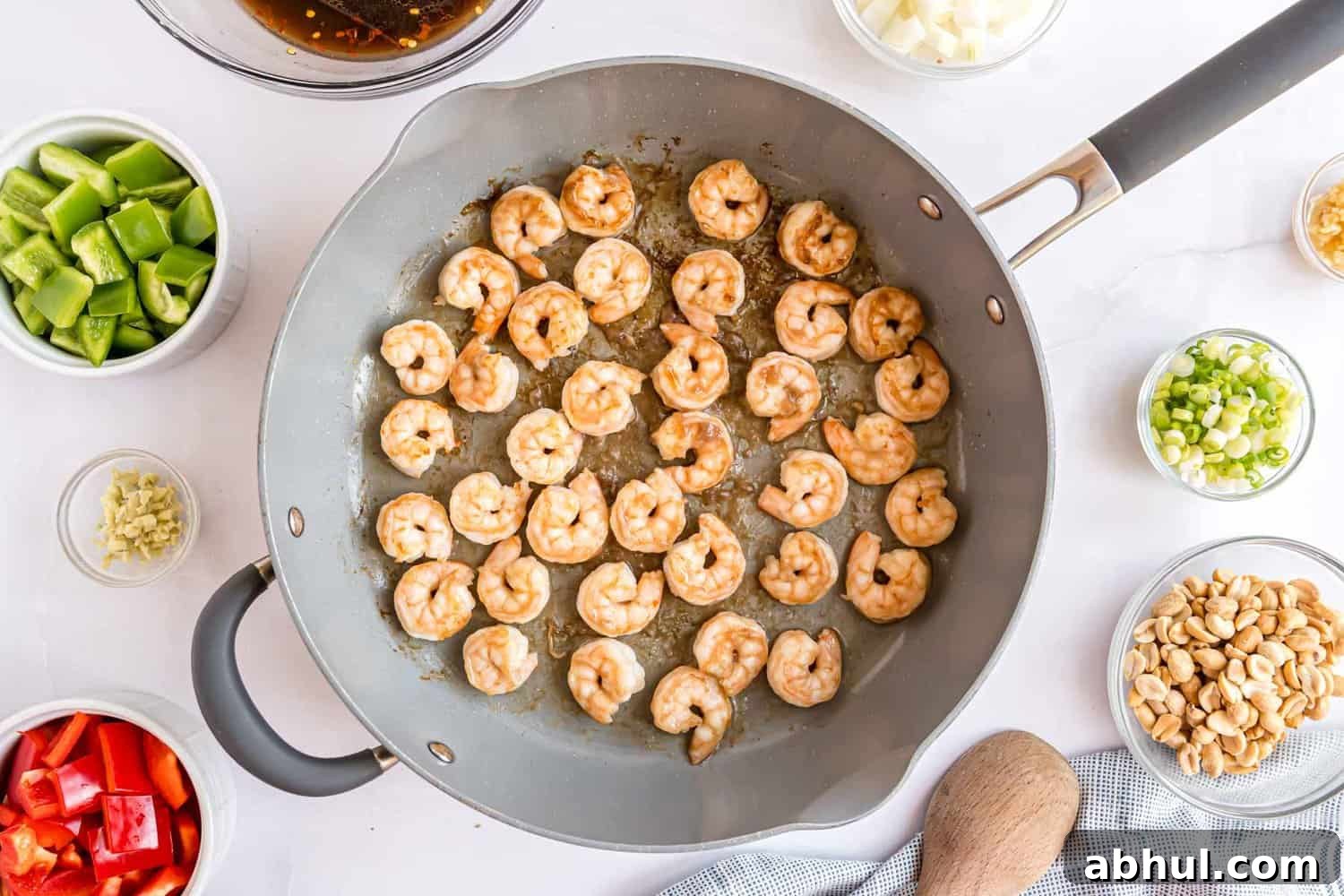 Shrimp cooking in a large frying pan.