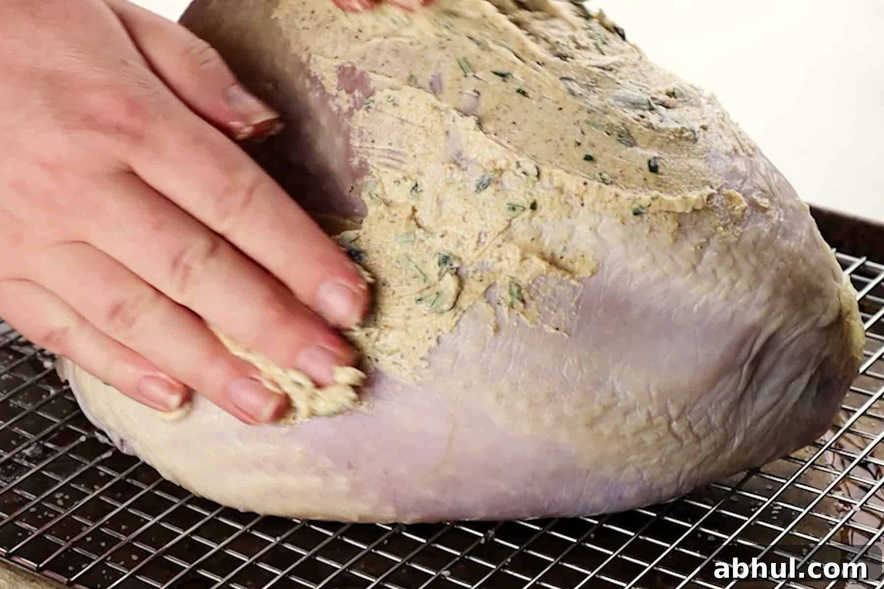 Rubbing herb butter over the turkey breast.