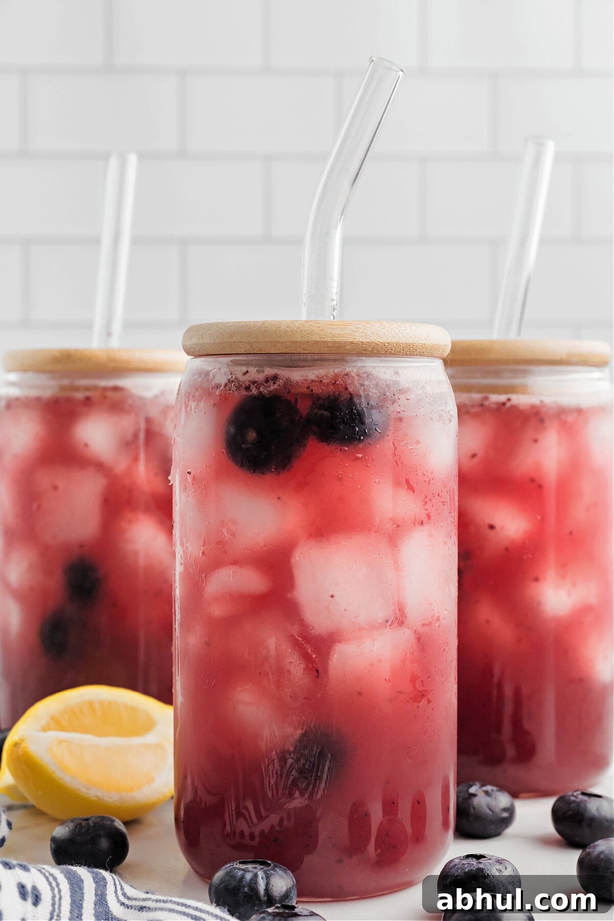 Refreshing Blueberry Lemonade Recipe with Fresh Citrus Twist 11 blueberry lemonade in glasses with lids and clear straws