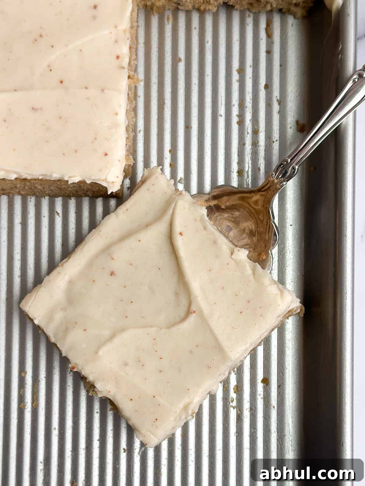 a close up of a single slice of banana cake on the sheet pan.