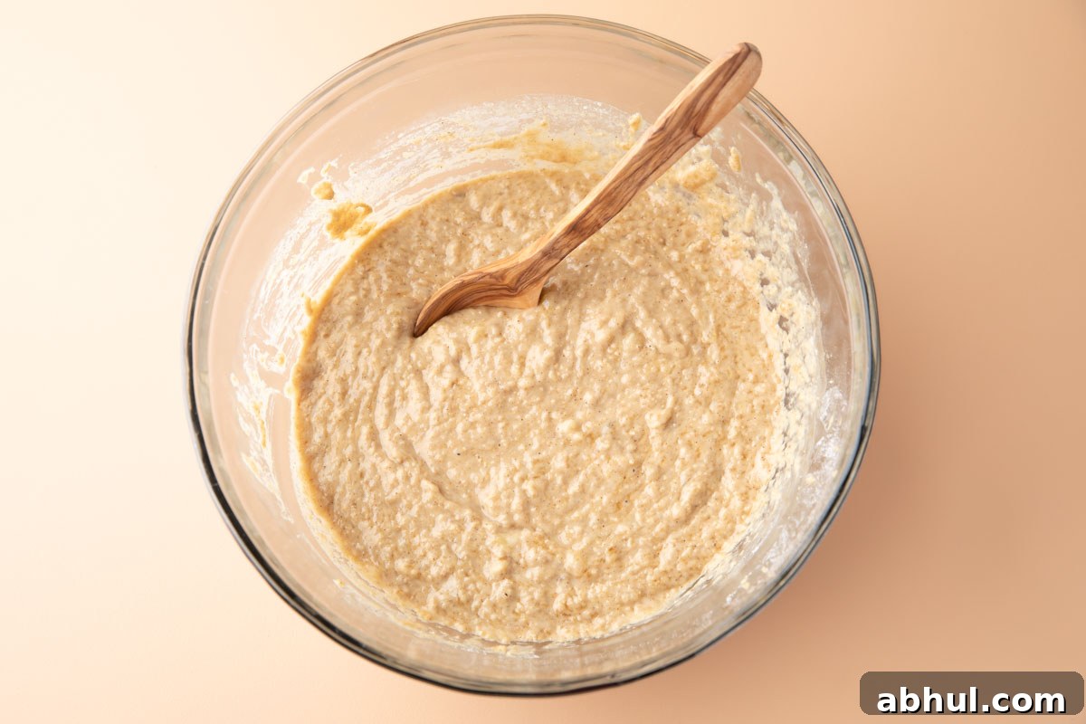 banana oatmeal muffin batter mixed together in a glass mixing bowl