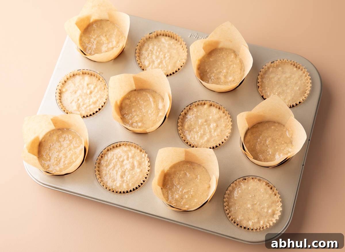 muffin batter in lined muffin cups in a nonstick muffin tin