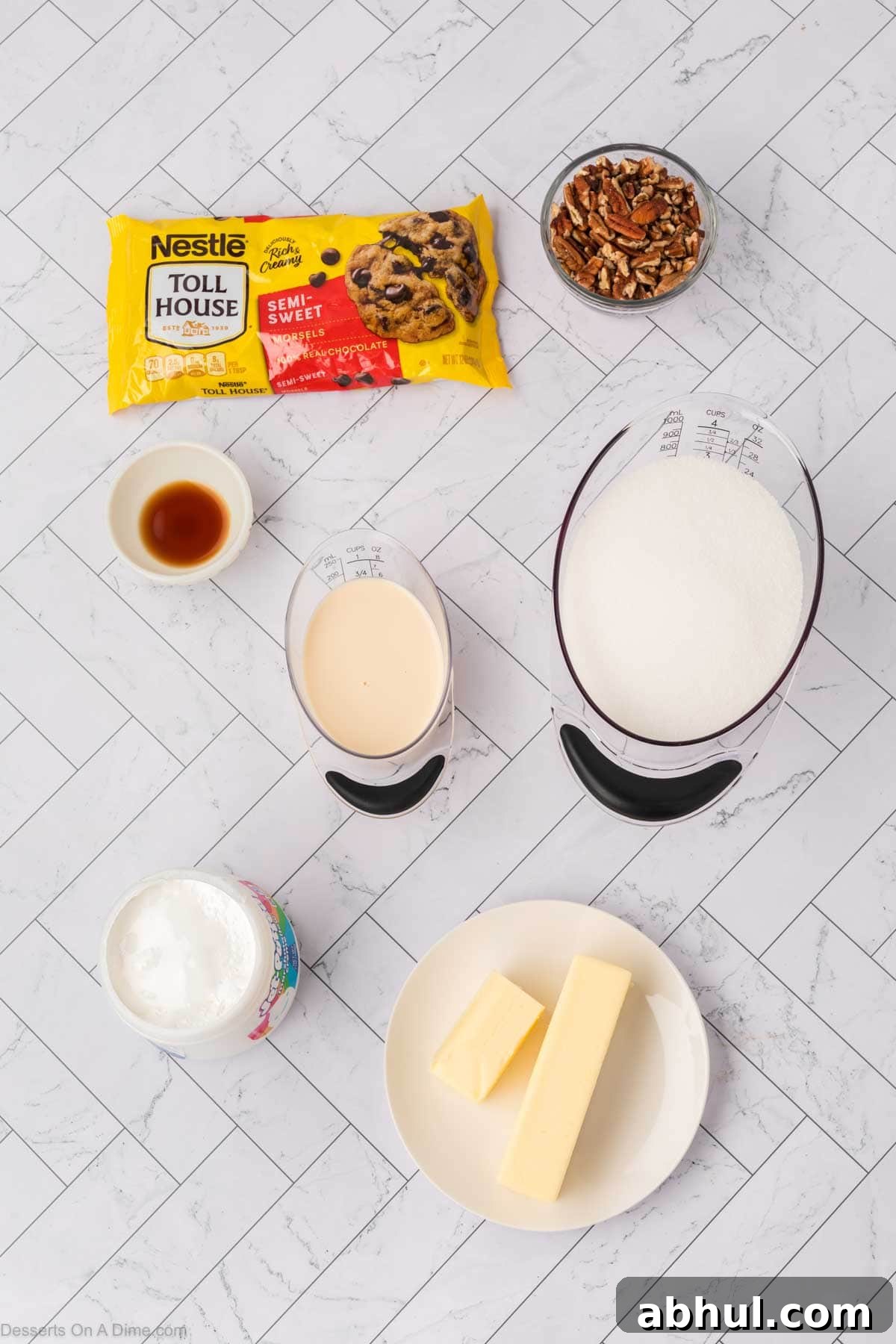 Ingredients for fudge - butter, sugar, milk, chocolate chips, marshmallow fluff, chopped pecans. 
