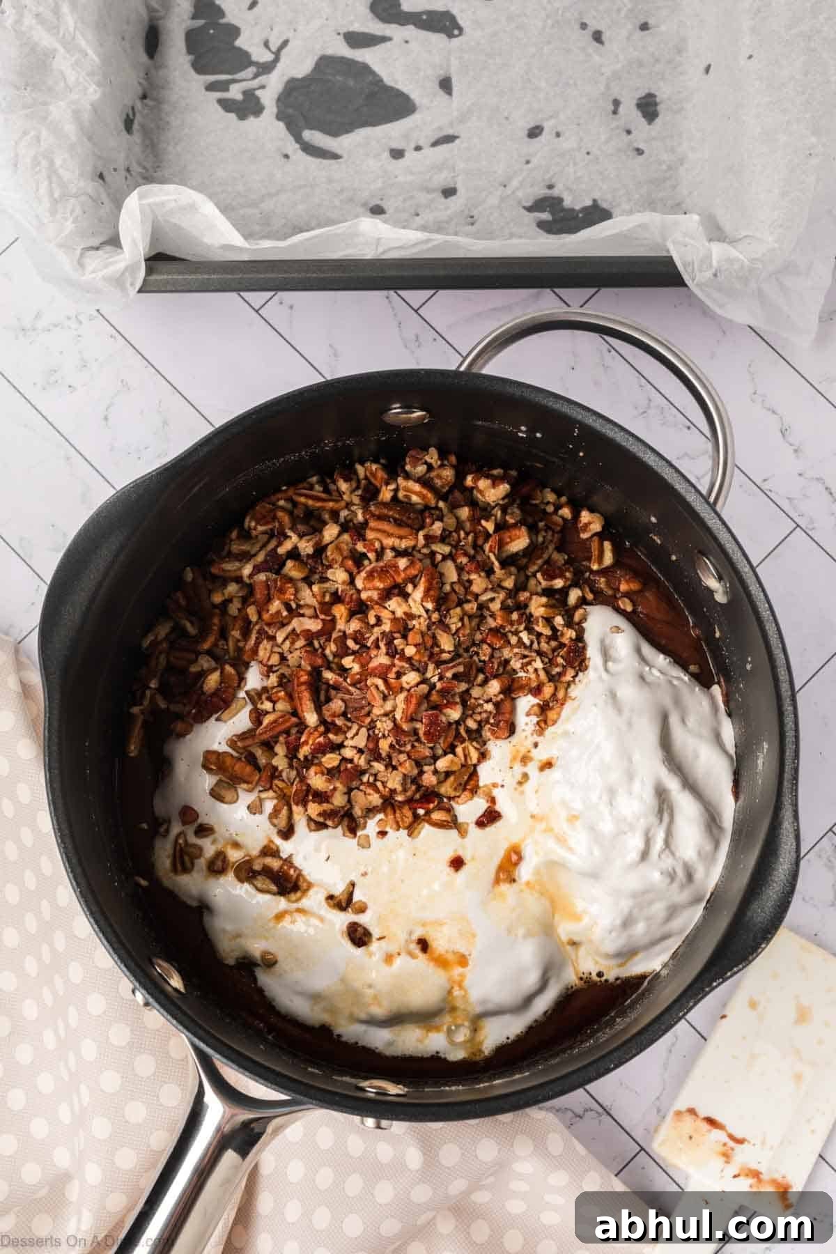 Marshmallow fluff and pecans in mixture. 