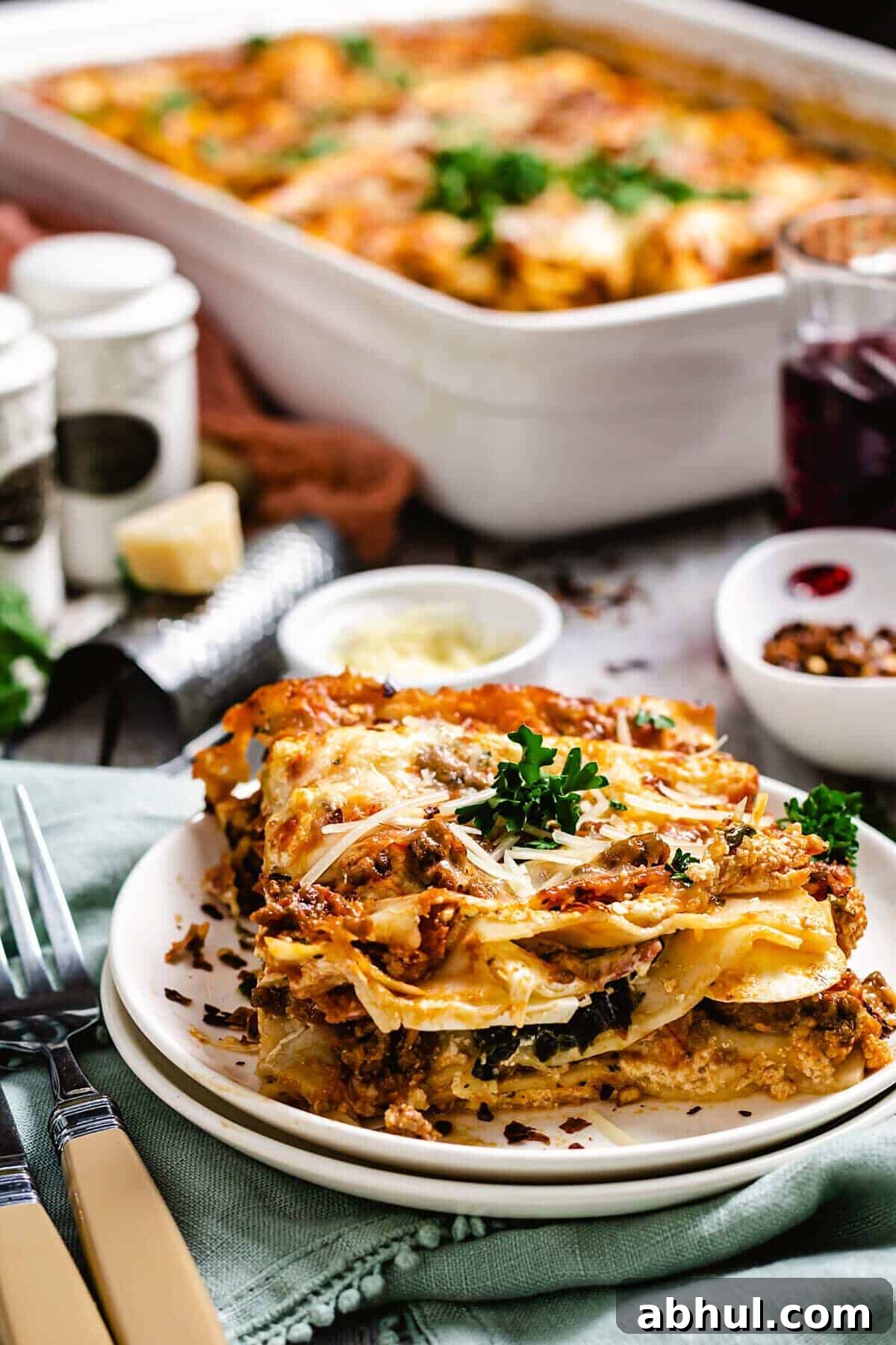 Authentic Sicilian Lasagna: Traditional Recipe & Tips 7 Slice of Sicilian lasagna plated on a table with the pan in the background.