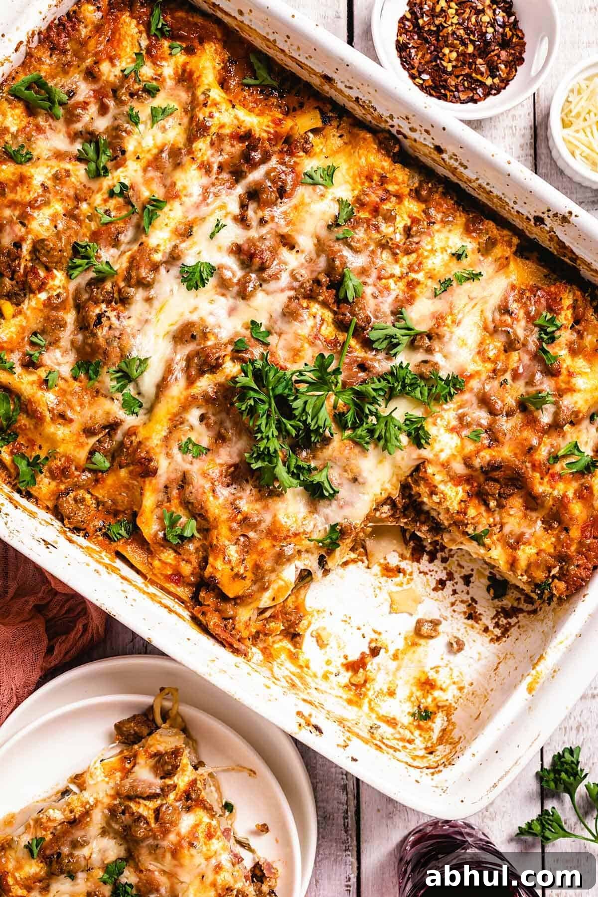 Authentic Sicilian Lasagna: Traditional Recipe & Tips 8 A pan with lasagna and parsley on a table with a plate.