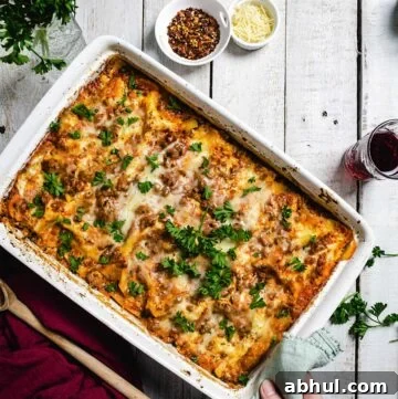 Authentic Sicilian Lasagna: Traditional Recipe & Tips 9 A person putting a white dish with lasagna on a rustic white table.