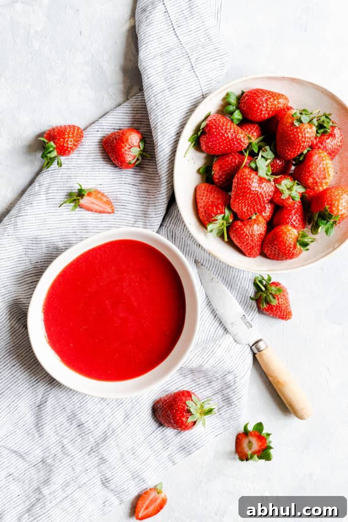 Strawberry Coconut Frozen Squares: Refreshing No-Bake Treat 7 top view of a bowl of strawberry puree and fresh strawberries