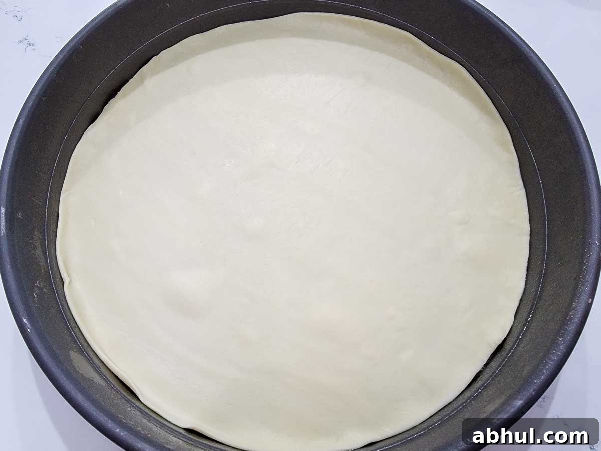 round pizza dough in a round pizza pan.