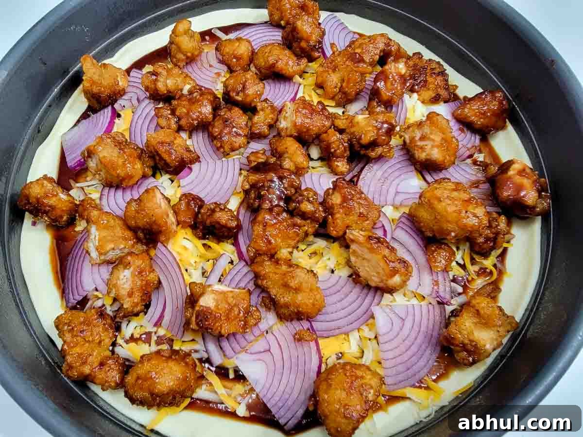 bbq popcorn chicken added to the top of the uncooked pizza.