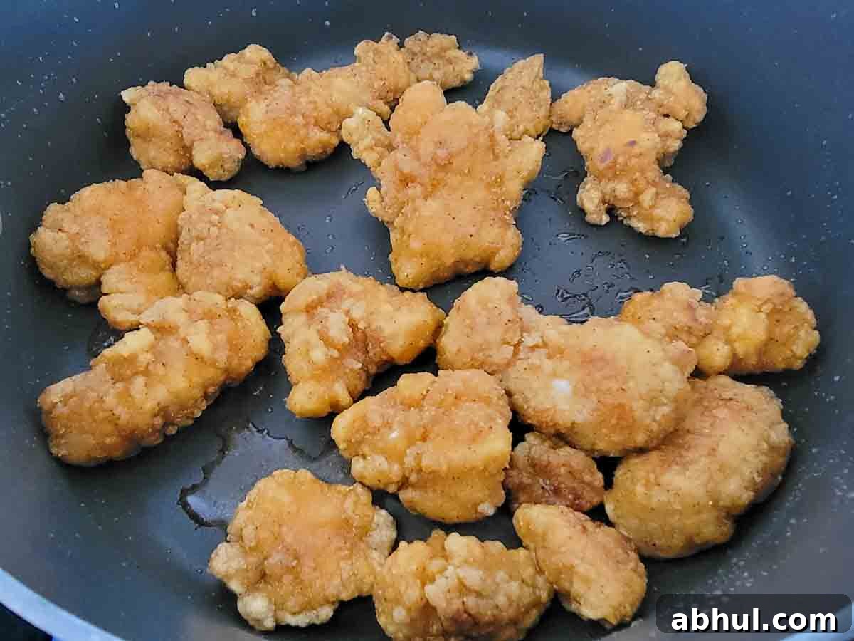 chicken nuggets cooking in a skillet.