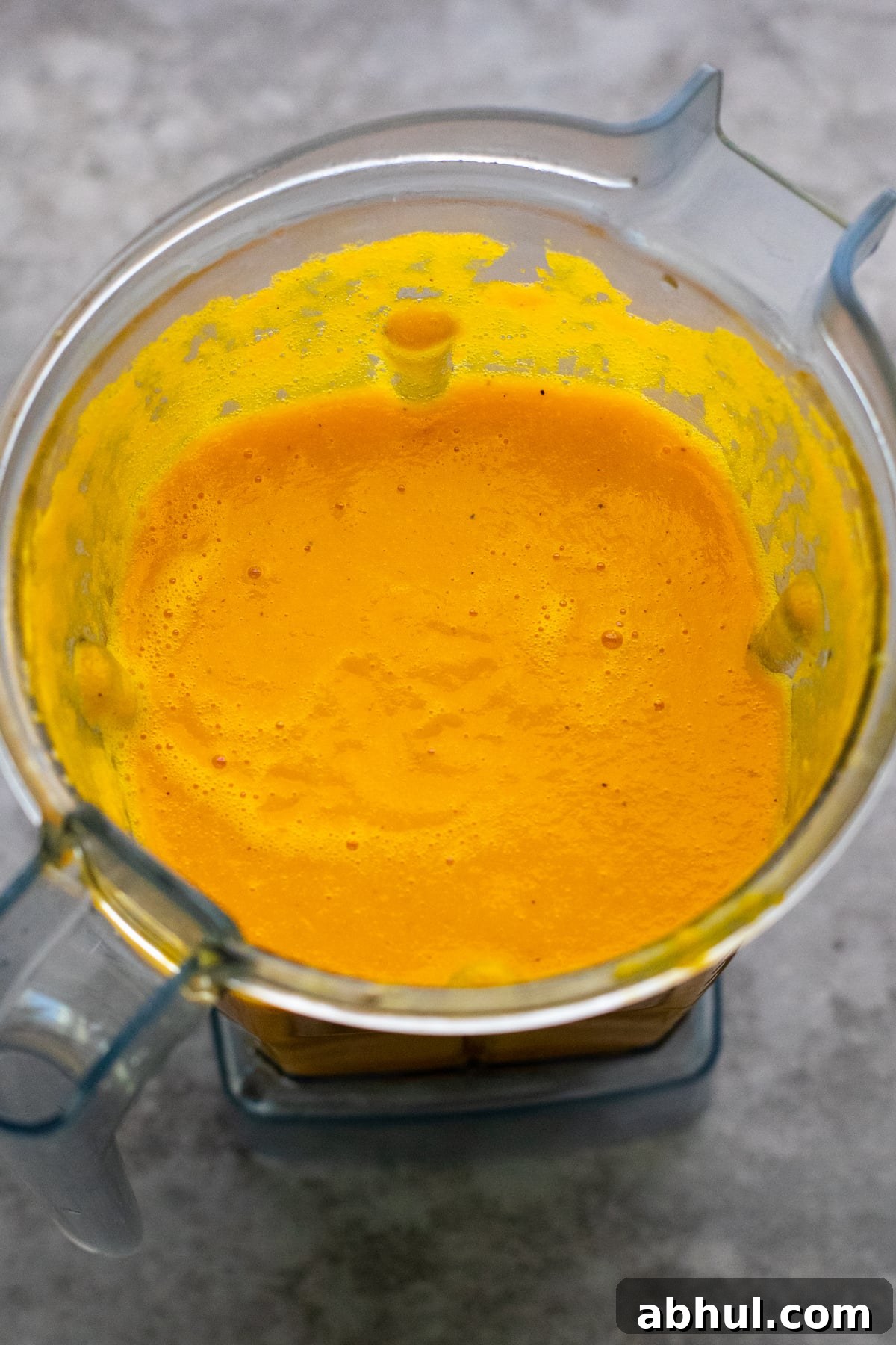 Orange carrot soup pureed in blender container.