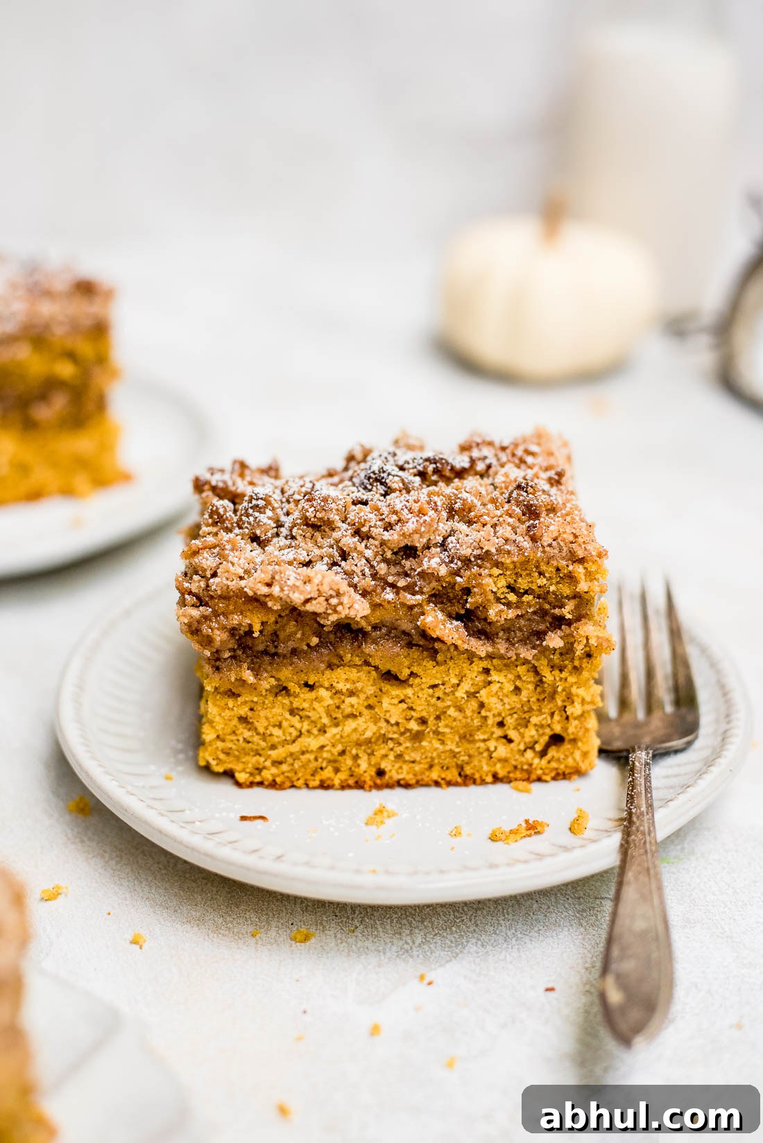 pumpkin coffee cake on small plate with fork on side