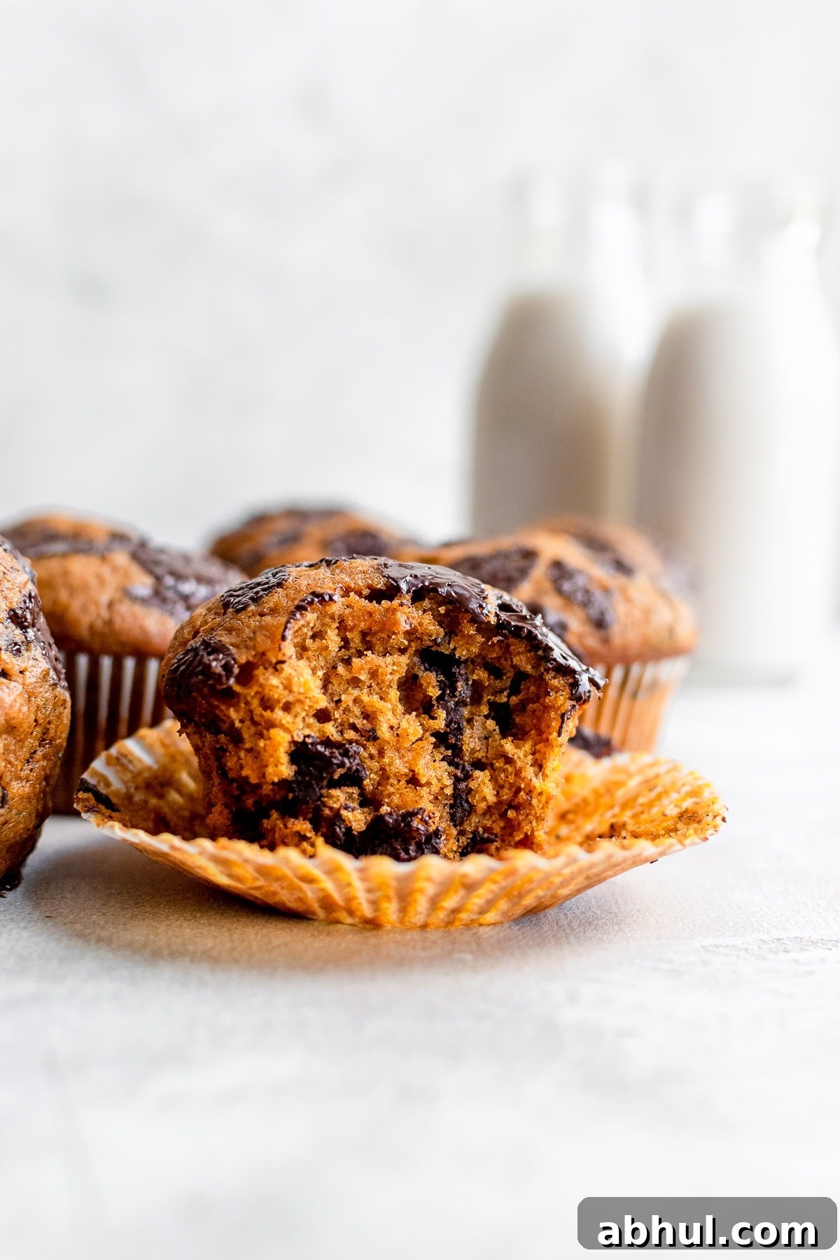 close up of pumpkin muffin in wrapper with bite missing