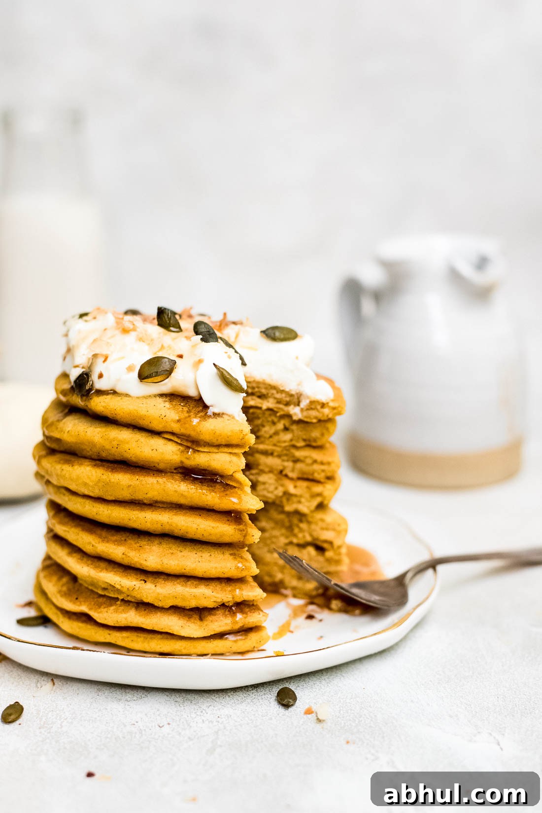 pumpkin pancakes drizzled with syrup being eaten close up