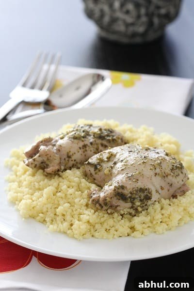 A Serving of Pesto Chicken Thighs with Italian Creme Sauce Over Parmesan Couscous