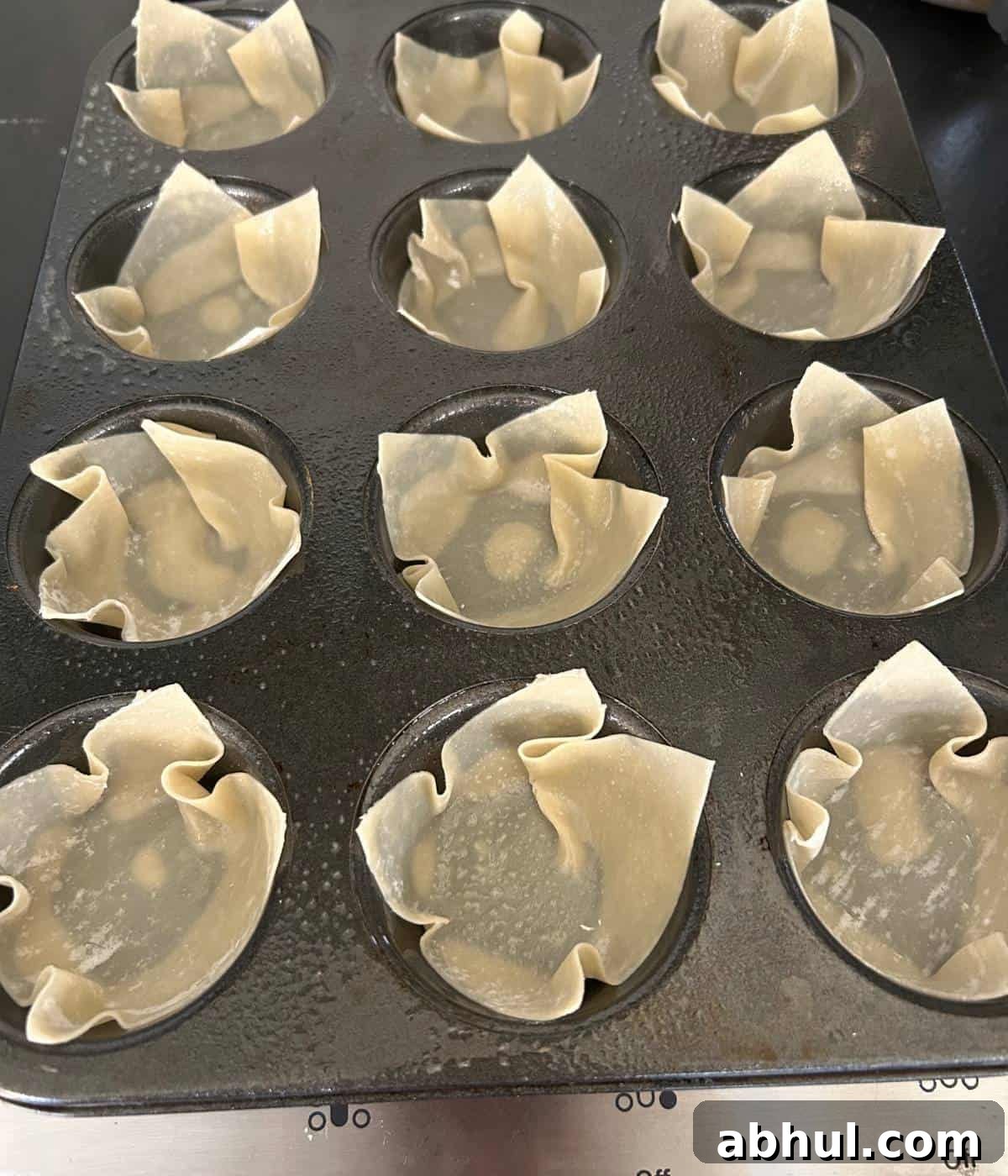 Wonton wraps in muffin tin sprayed with cooking spray.