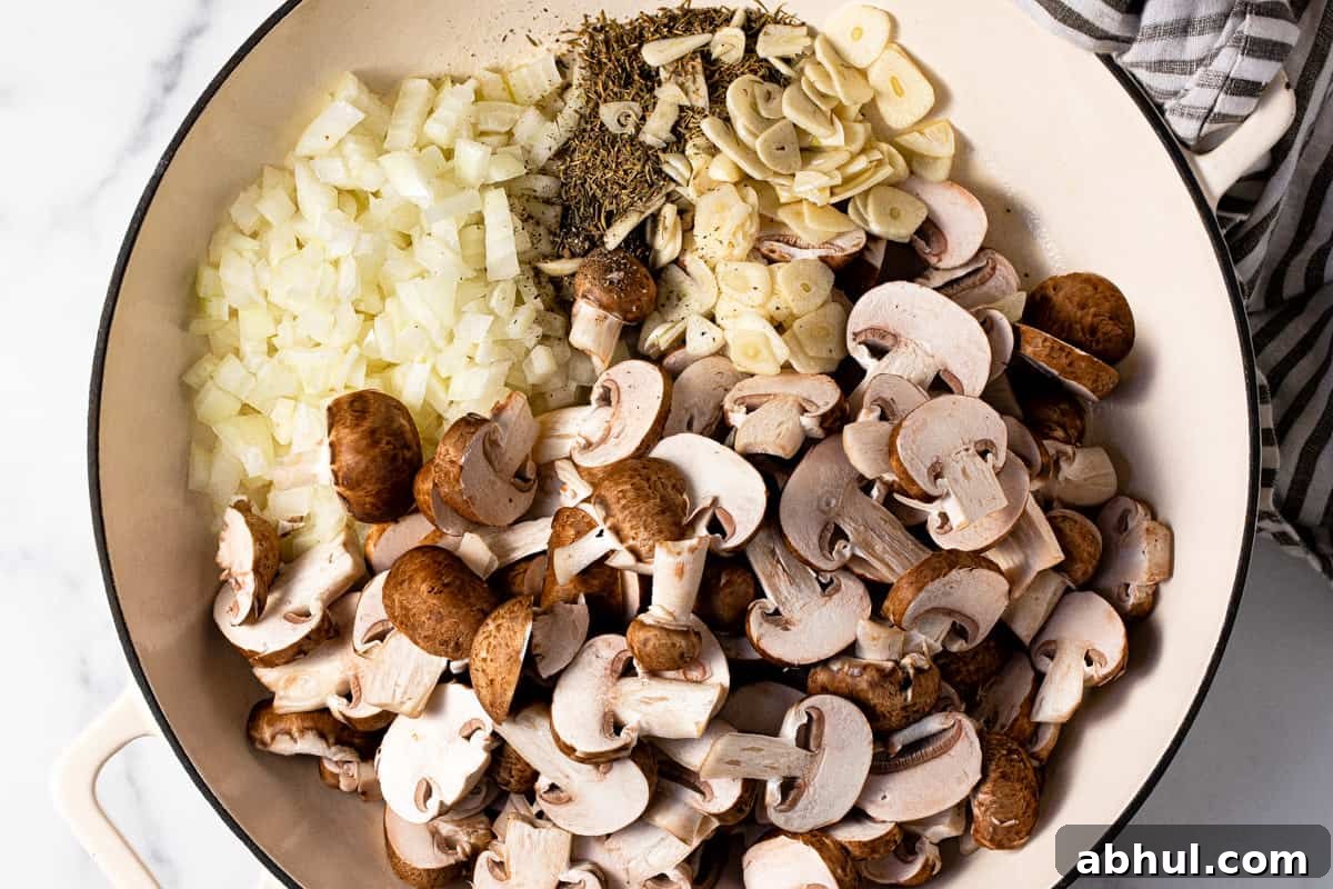 Large pan filled with sliced mushrooms garlic onion and dried herbs