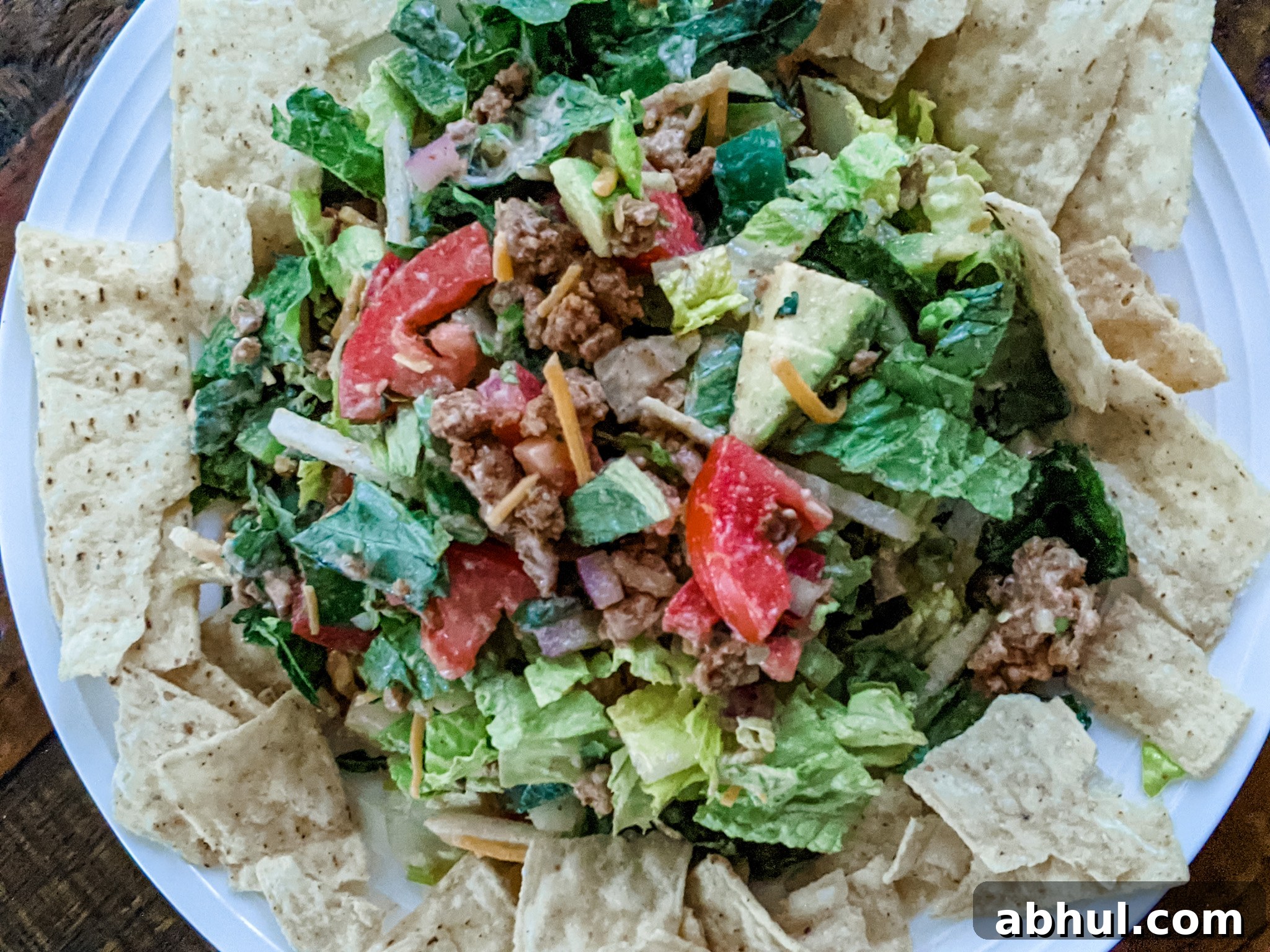 The Chicken Taco Salad plated and mixed, surrounded by tortilla chips for dipping.