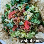 The Chicken Taco Salad plated and mixed, surrounded by tortilla chips for dipping.