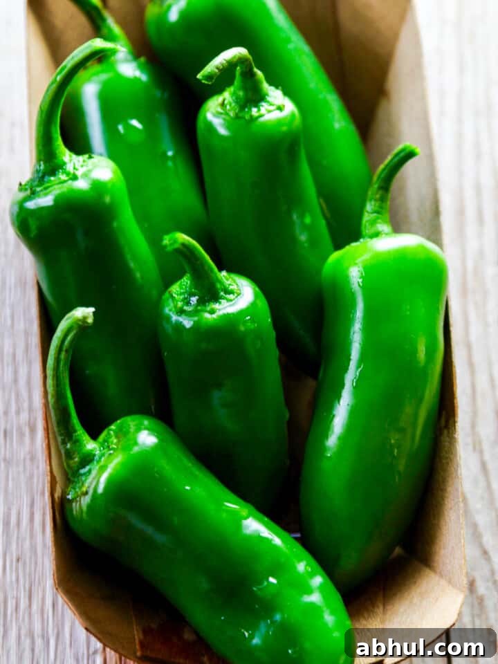 A small wooden container basket filled with bright green jalapeños