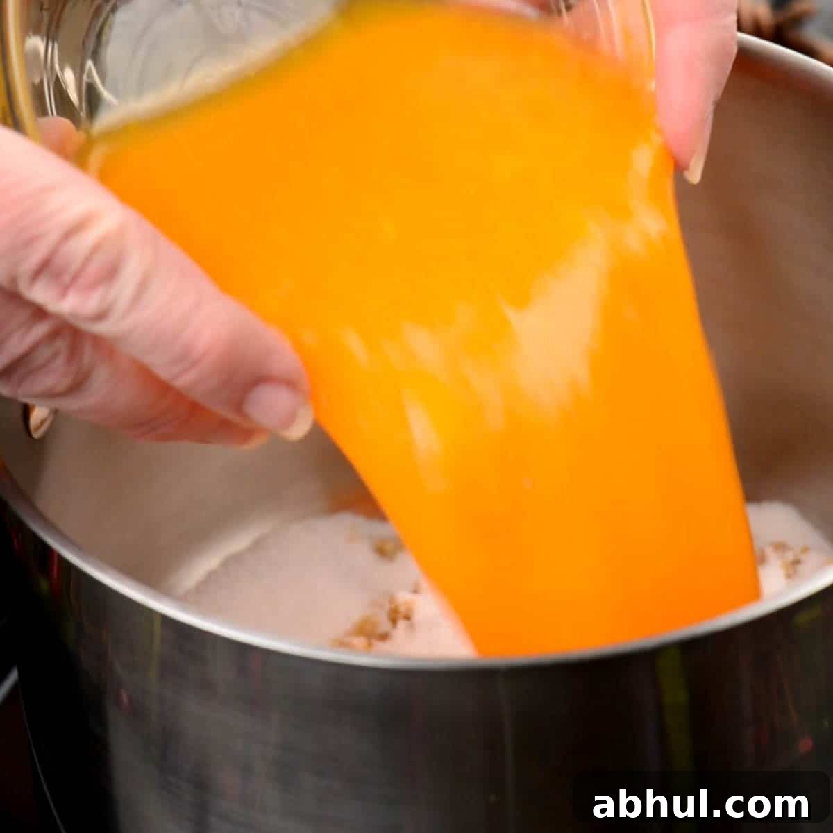 pouring orange juice into pan