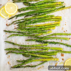 Oven roasted asparagus and lemon slices on a baking sheet lined with parchment paper.
