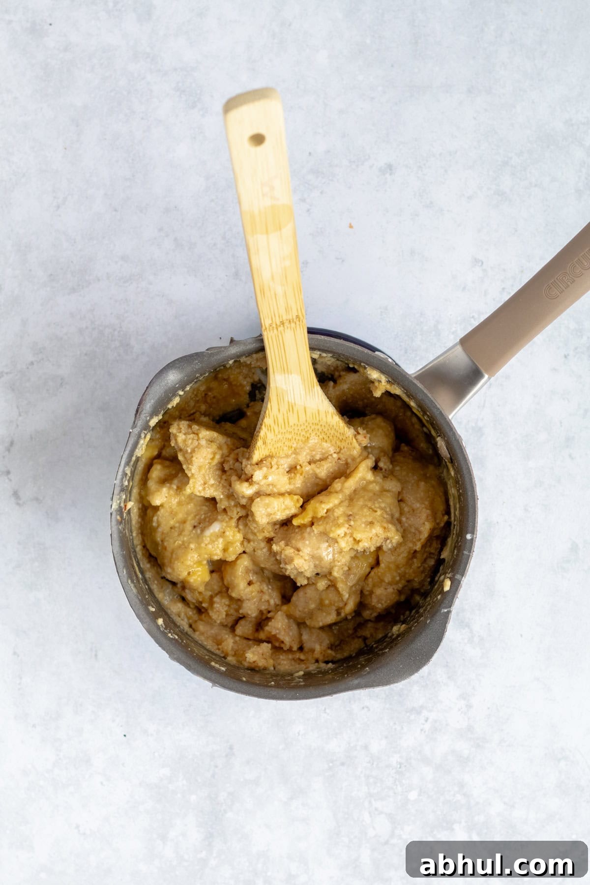 Fluffy Passover Matzo Meal Sandwich Rolls 6 eggs mixing into matzo meal batter with twooden spoon.