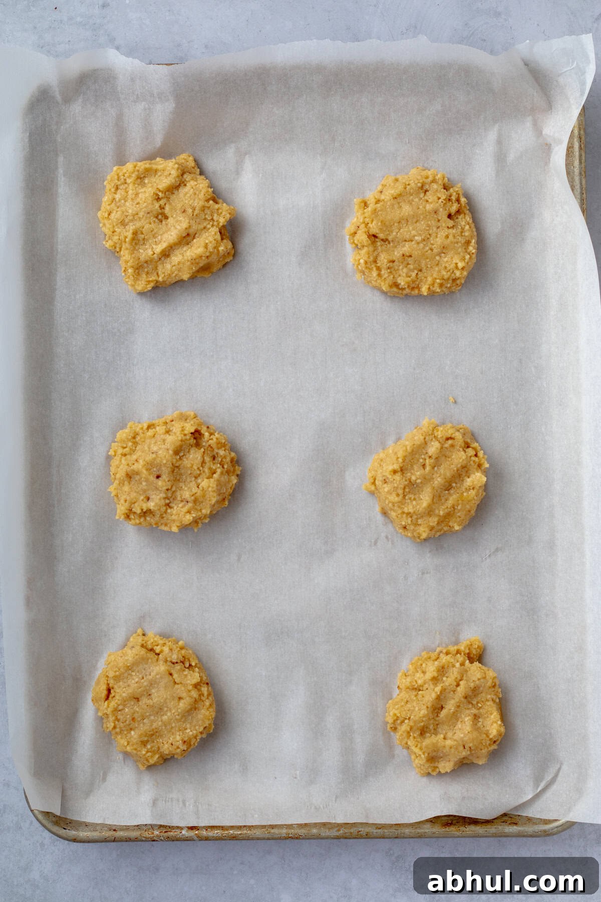 Fluffy Passover Matzo Meal Sandwich Rolls 7 6 raw passover rolls on a parchment lined sheet tray.