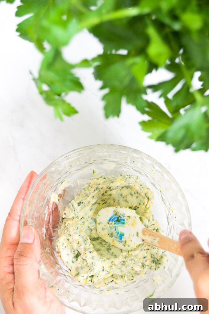 Herb-Butter Compound for Juicy Roasted Turkey 5 A person stirs a bowl of butter with garlic, herbs and orange zest