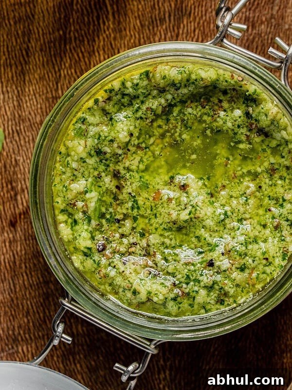 Arugula pesto in a class jar on a wooden tray.