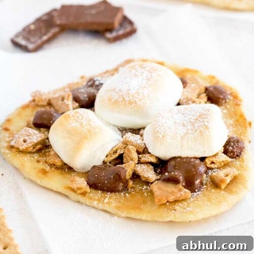 Hot off the oven s'more flatbread dessert pizza on a white surface