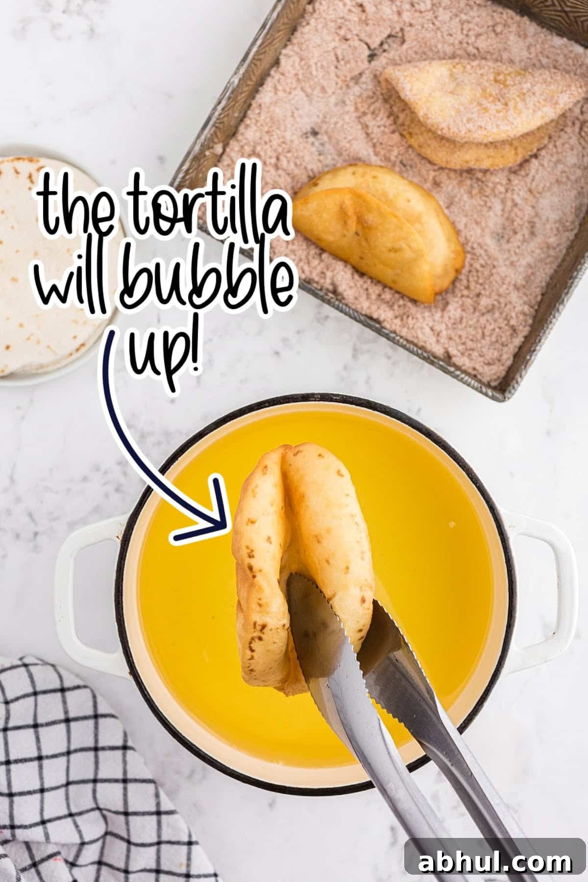 Finished fried tortilla is bubbly and puffy.
