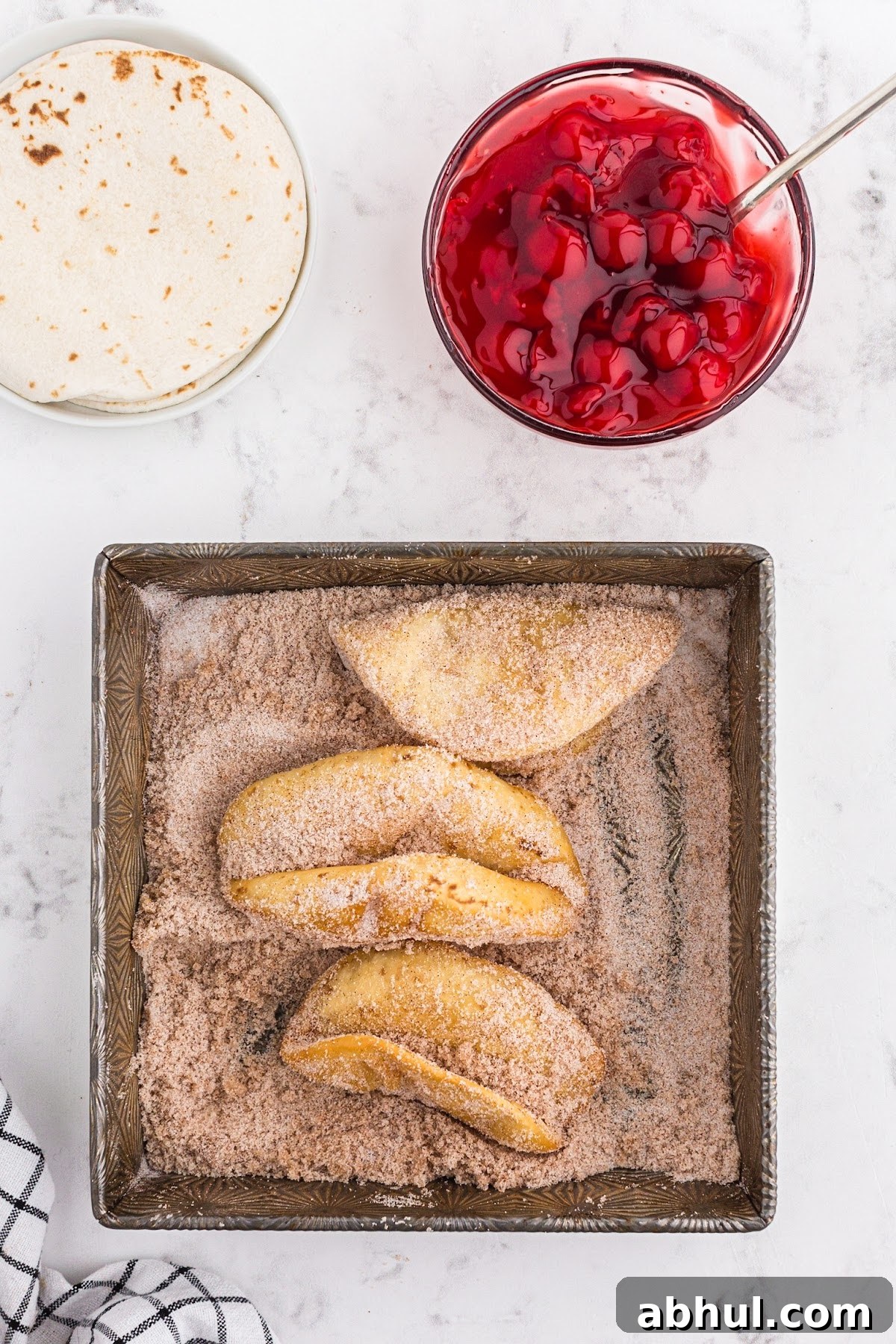 Dusting the fried tortillas in the cinnamon and sugar mixture.
