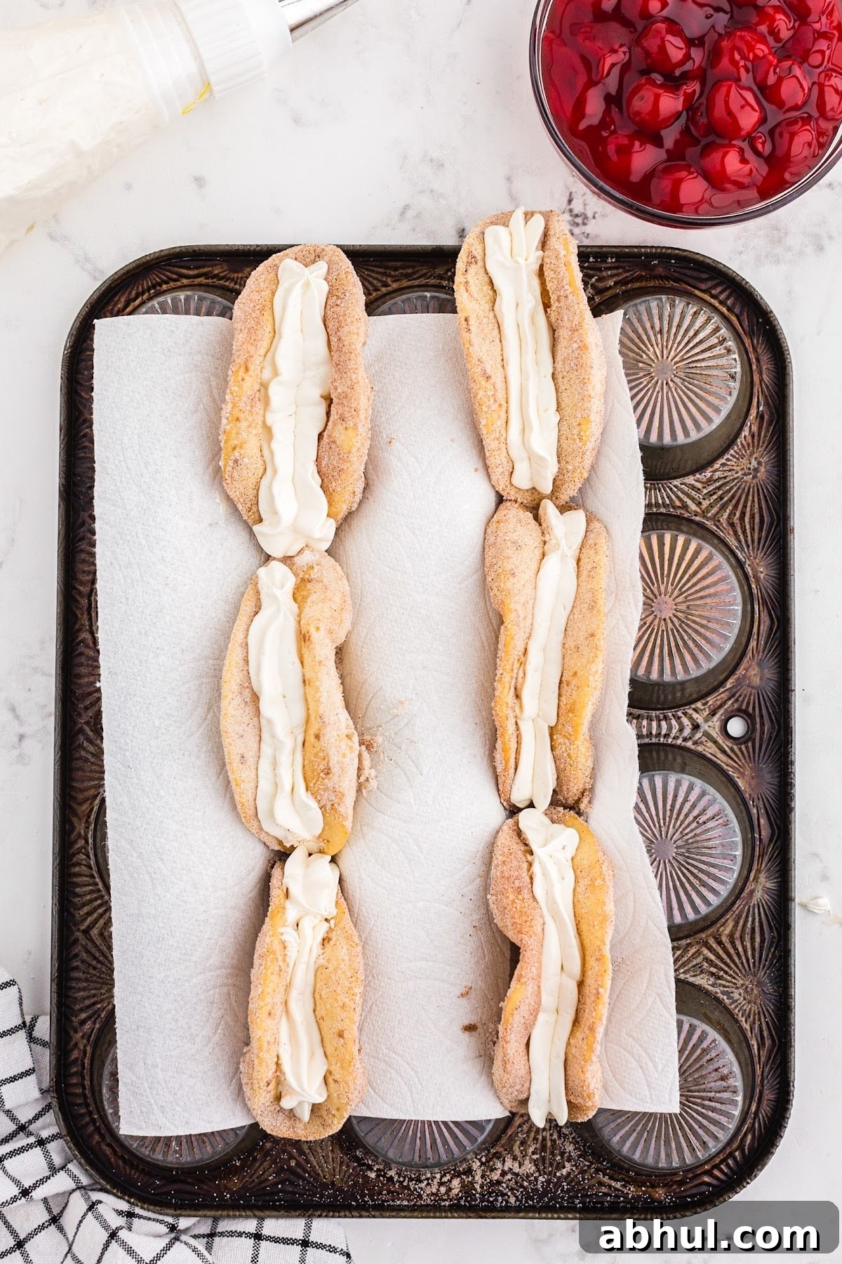 Piping in the cheesecake filling into the taco shells.
