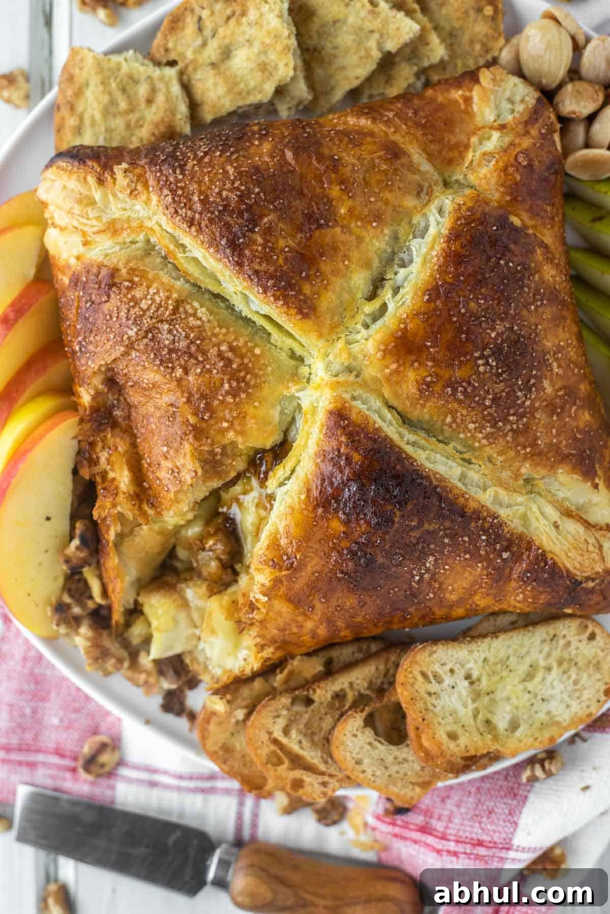 Baked brie in puff pastry cut into on plate.