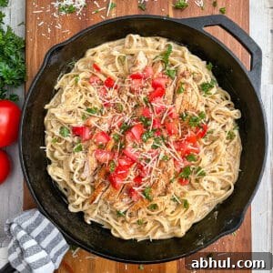 the most amazing Cajun chicken alfredo recipe served with diced tomatoes and chopped parsley