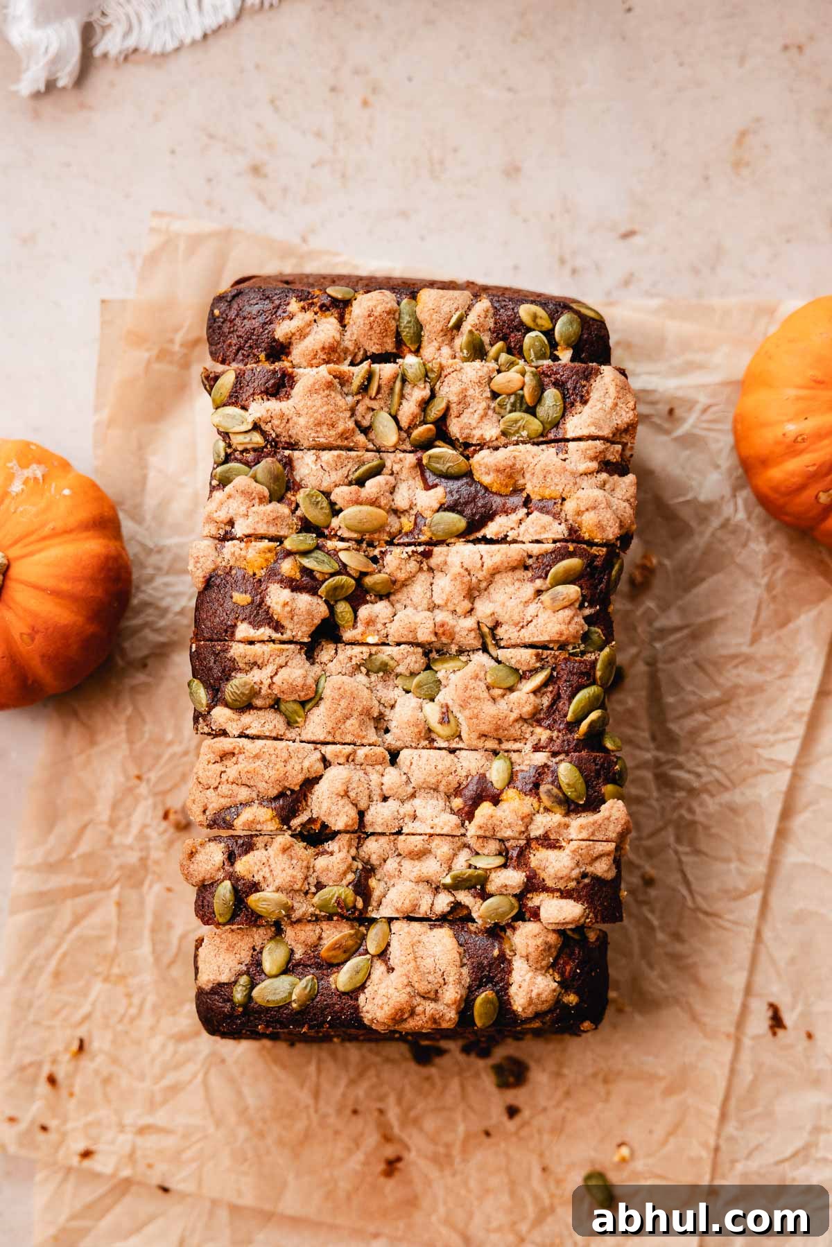 sliced pumpkin bread loaf with streusel pumpkin seed topping