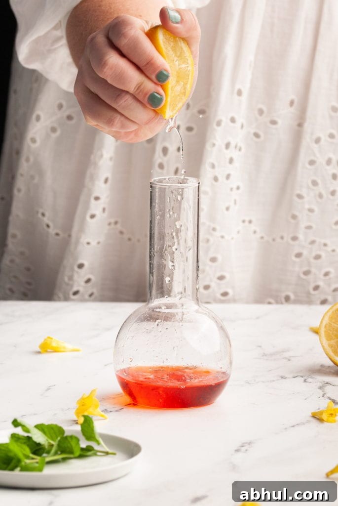 squeezing lemon juice into aperol bourbon cocktail