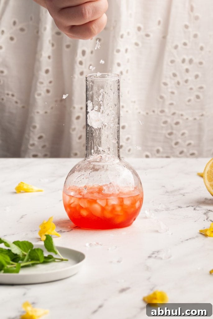 adding crushed ice to vibrant red cocktail