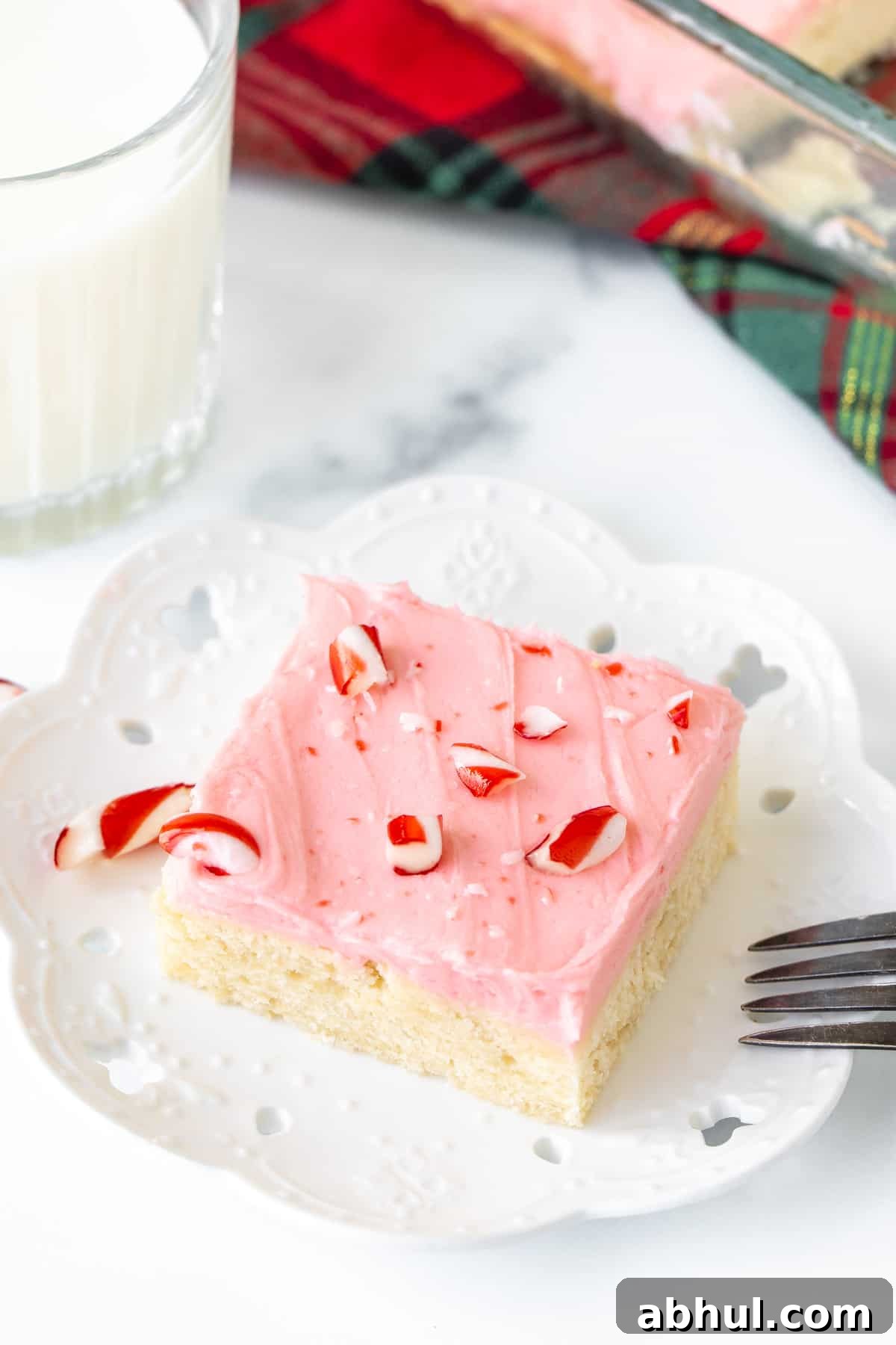 Slice of peppermint sugar cookie bars with glass of milk
