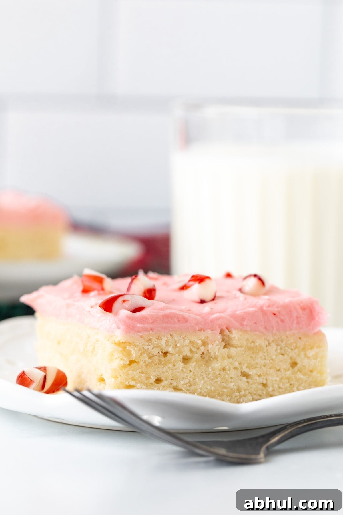 Sugar cookie bar topped with pink peppermint frosting and crushed candy canes on top