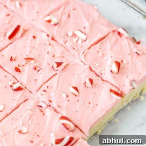Pan of frosted peppermint sugar cookie bars with crushed candy canes on top